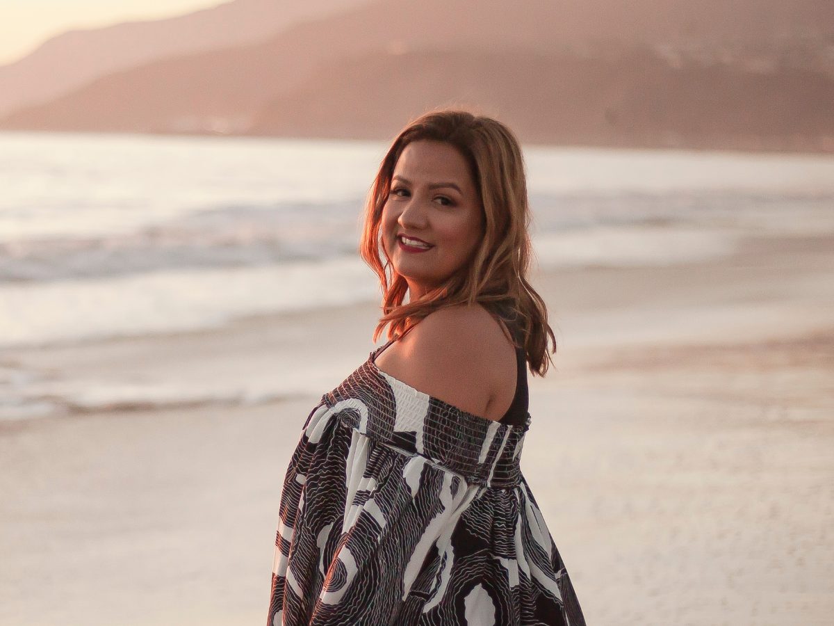 Lorena Coyle sonriendo en la playa al atardecer